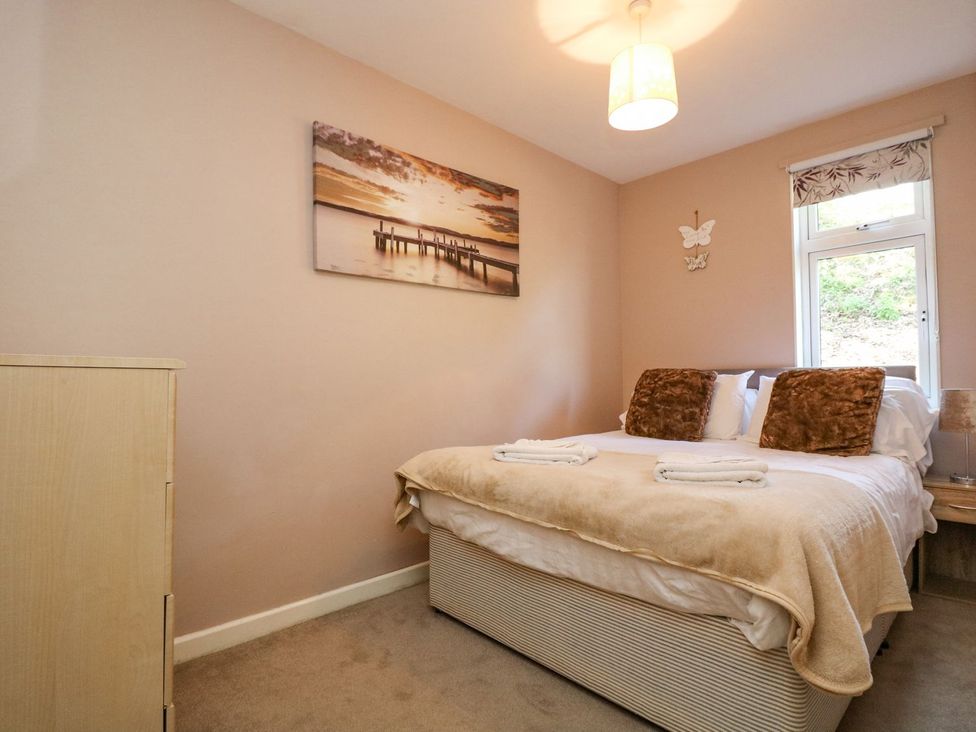 A bedroom with a bed and window at Valley Lodge 61 in Callington