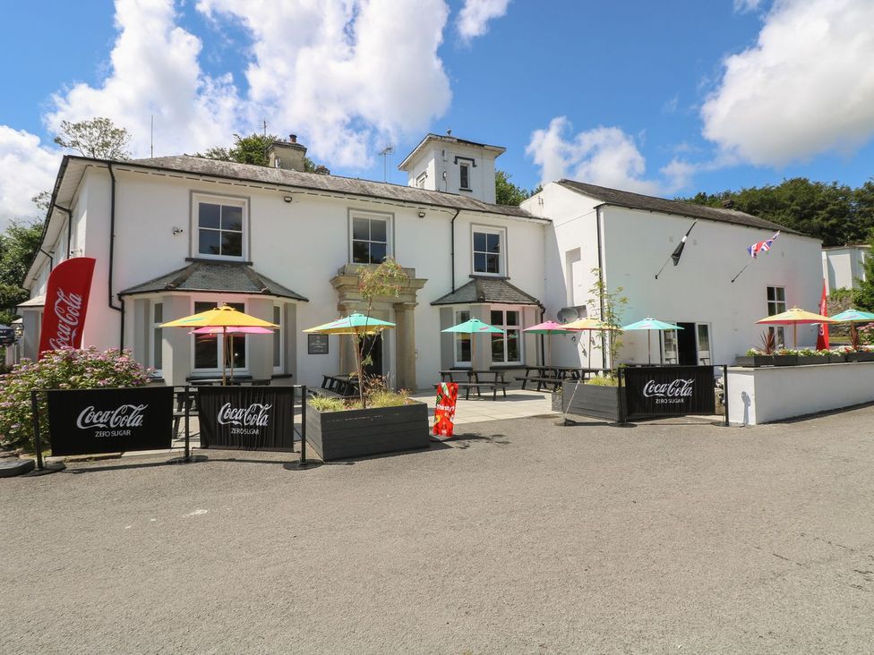 An outdoor seating area with tables and umbrellas at Valley Lodge 61 in Callington