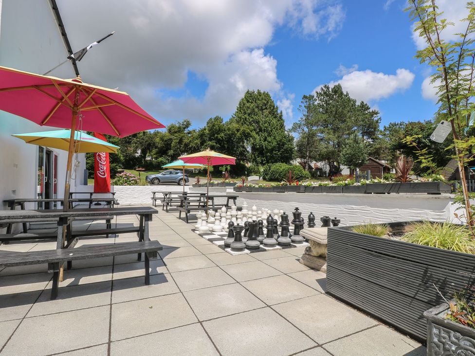 An outdoor area with benches, tables, umbrellas, chess pieces at Valley Lodge 61 Callington