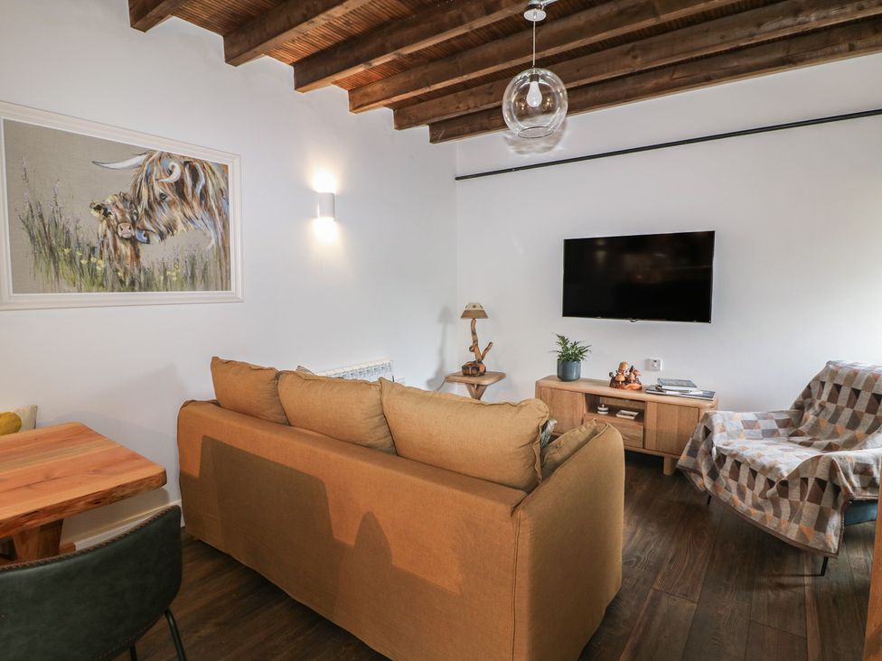 A living room with a sofa, table, lamp, and television at The Loft in Glenmore, County Kilkenny