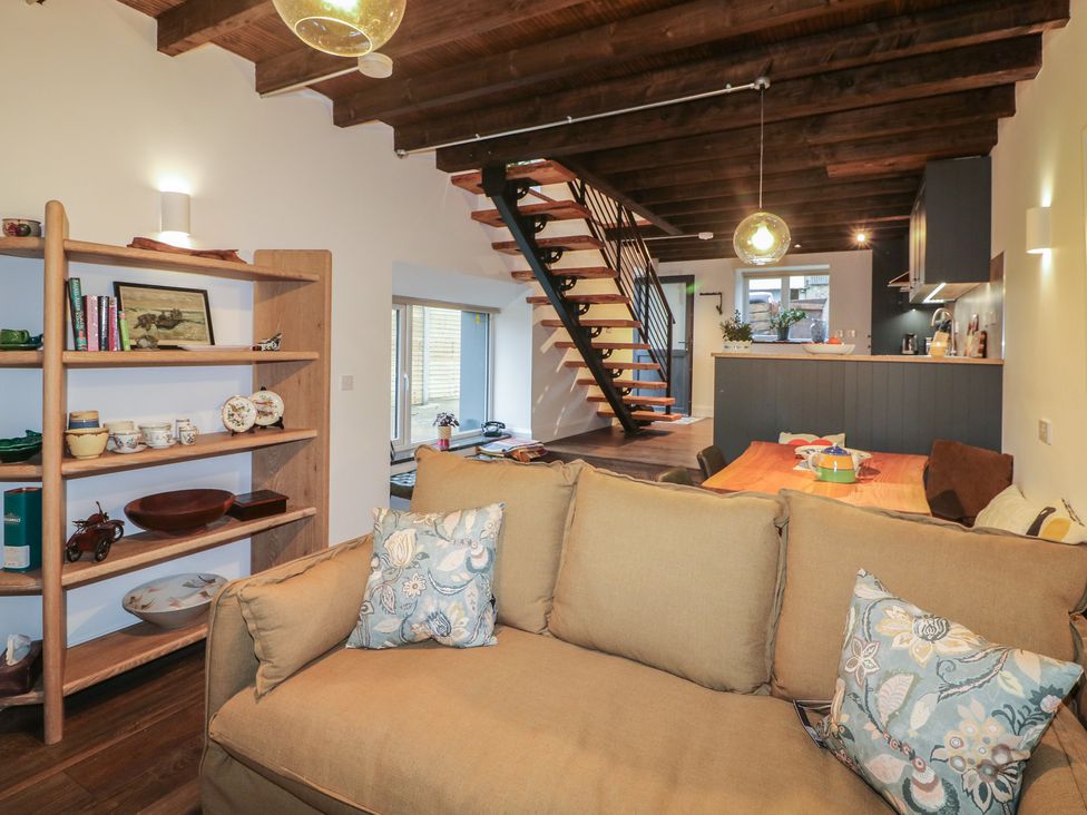 A living room with a staircase and kitchen area at The Loft in Glenmore, County Kilkenny