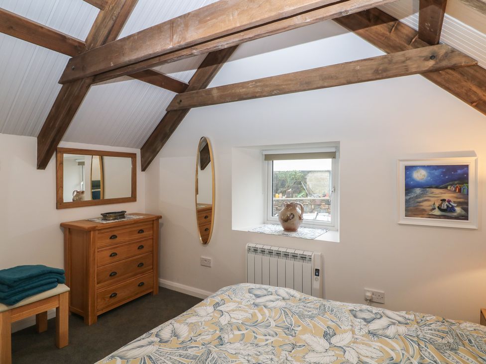 A bedroom with a bed, dresser, and mirror at The Loft in Glenmore, County Kilkenny