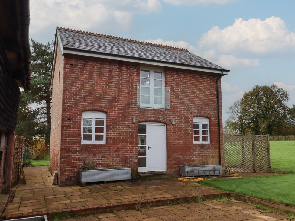A brick building with windows and a door in the outdoor area at Hilldown Granary in Crediton