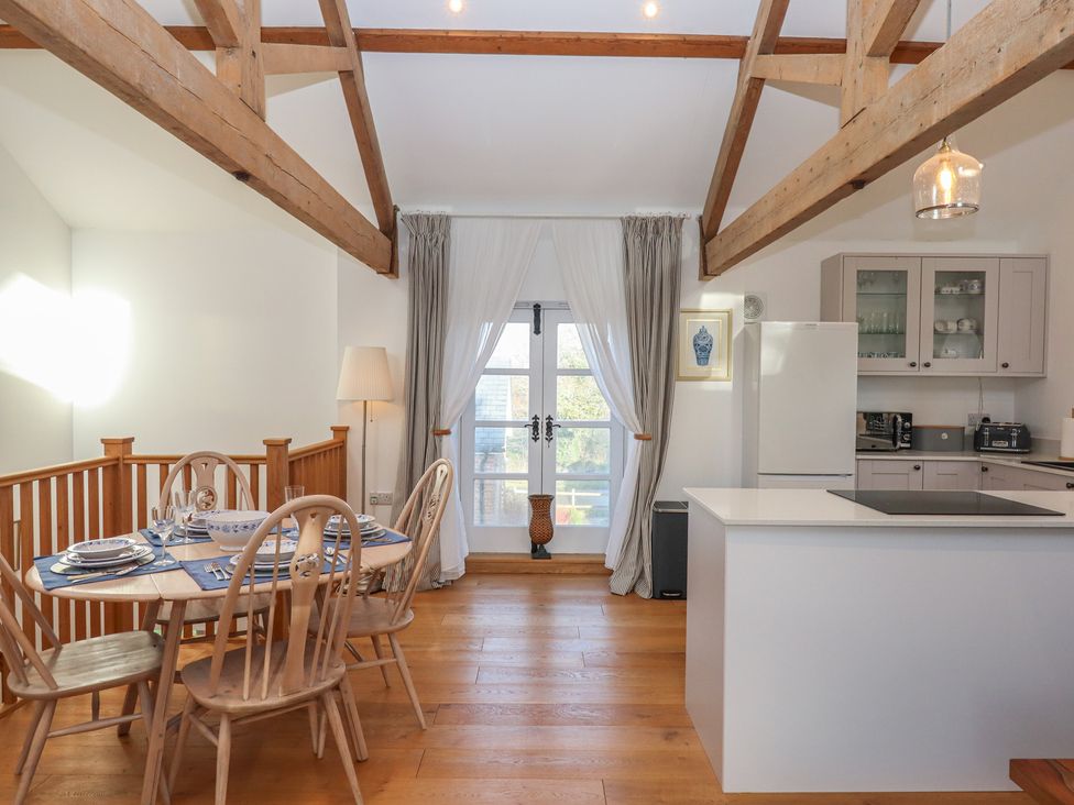 A kitchen with dining table and chairs at Hilldown Granary near Bow