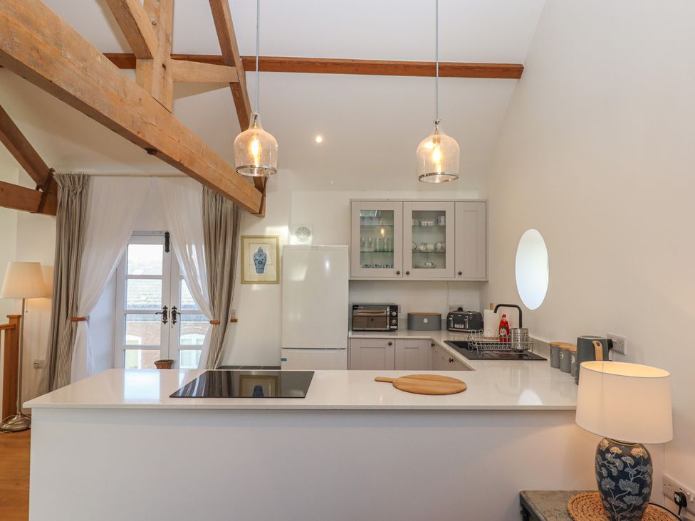 A kitchen with appliances and a kitchen island at Hilldown Granary near Bow