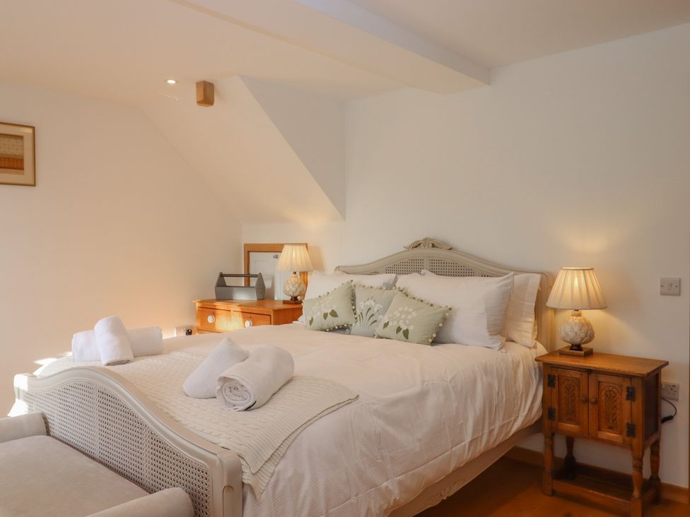 A bedroom with a bed and bedside table at Hilldown Granary near Bow