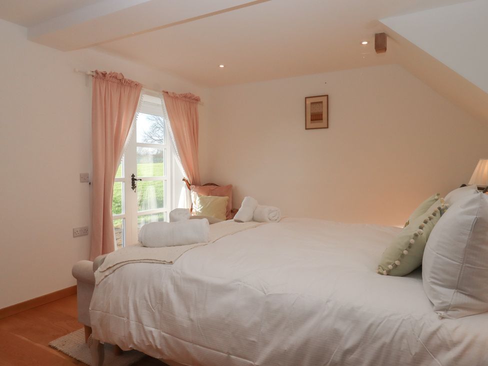 A bedroom with a bed and window at Hilldown Granary near Bow