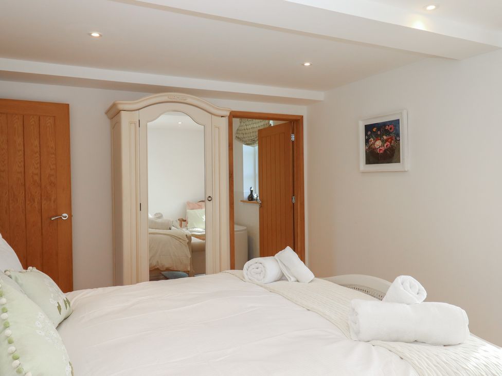 A bedroom with a bed and wardrobe at Hilldown Granary near Bow