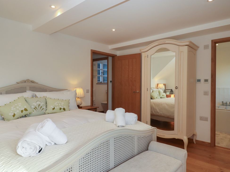 A bedroom with a bed and wardrobe at Hilldown Granary near Bow