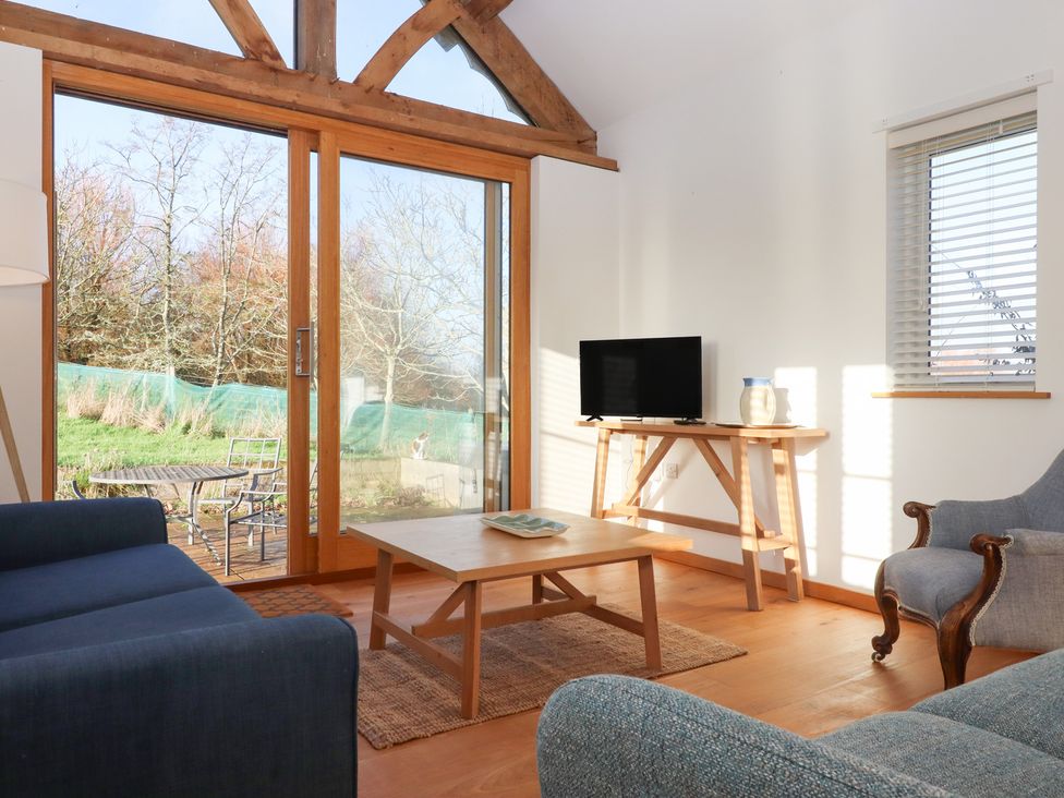 A living room with a sofa and table at Hilldown Cott near Bow