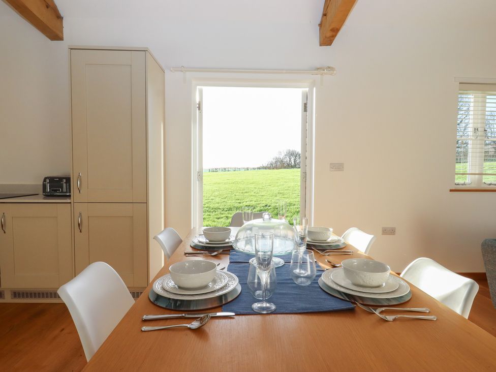 A dining room table set with plates and glasses at Hilldown Cott near Bow