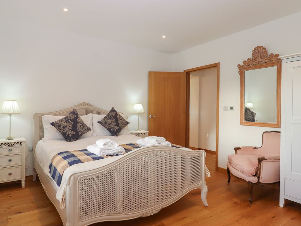 A bedroom with a bed and armchair at Hilldown Cott near Bow