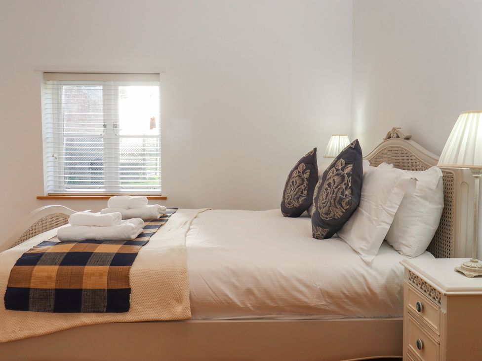 A bedroom with a bed and pillows at Hilldown Cott near Bow