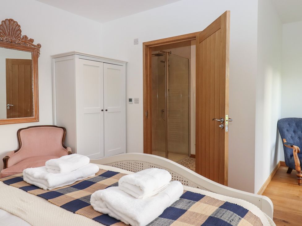 A bedroom with a bed and wardrobe at Hilldown Cott near Bow
