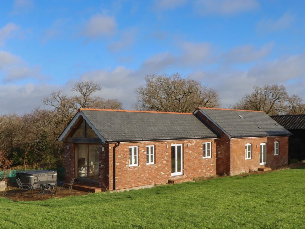 A house with a garden and seating area at Hilldown Cott near Bow