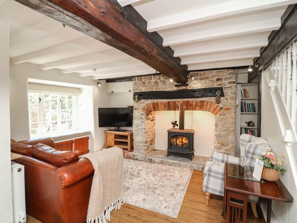 A living room with a fireplace and television at Freya Cottage in Metheringham