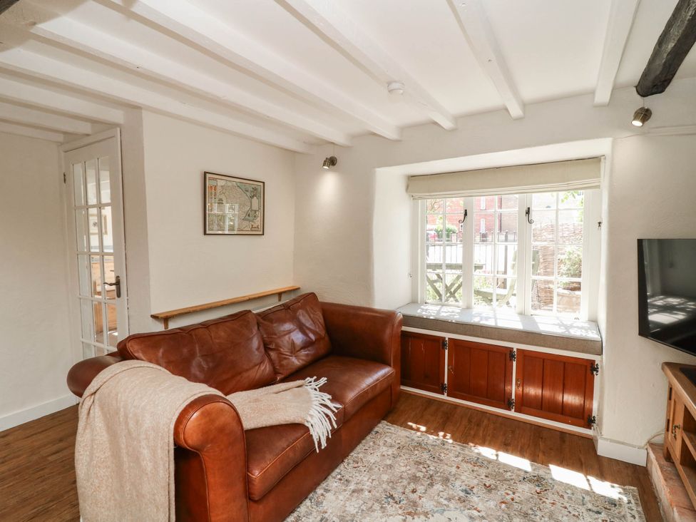 A living room with a sofa and television at Freya Cottage in Metheringham