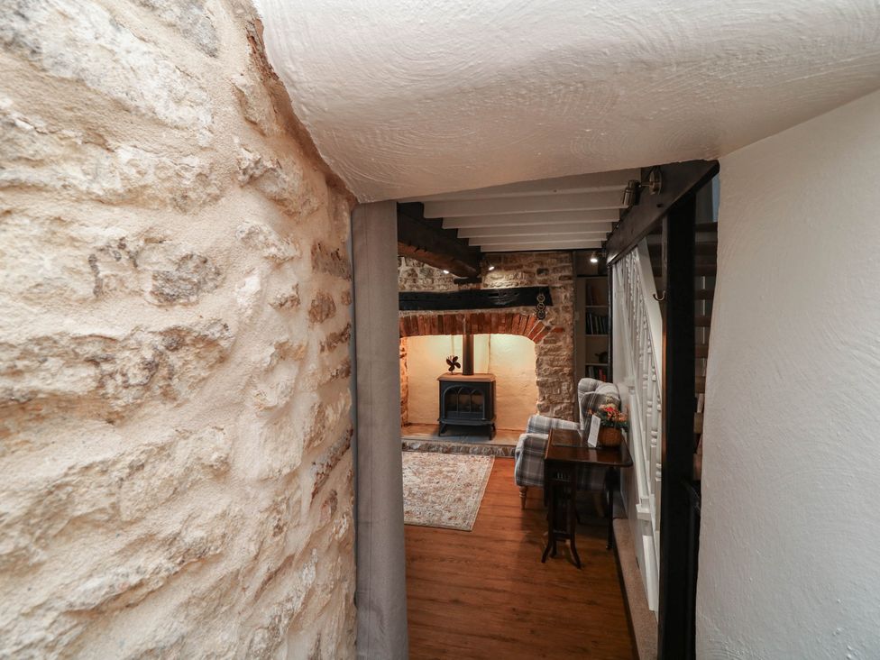 A living room with a fireplace and seating area at Freya Cottage in Metheringham