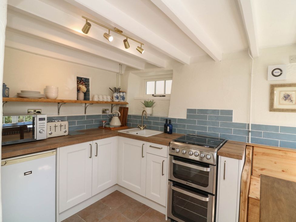 A kitchen with a stove and sink at Freya Cottage in Metheringham