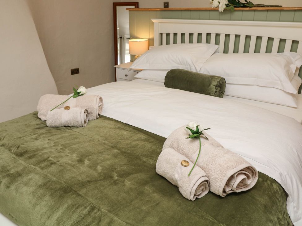 A bedroom with a bed and towels at Freya Cottage in Metheringham