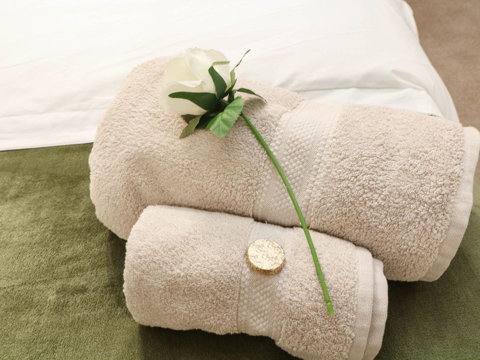 Towels with a flower and coin at Freya Cottage in Metheringham