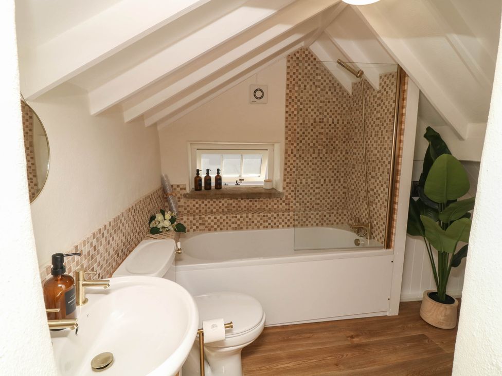 A bathroom with a bathtub and sink at Freya Cottage in Metheringham