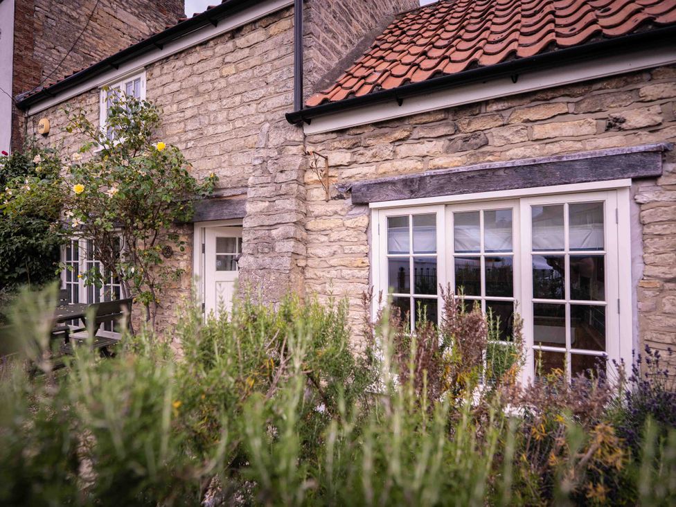 An exterior view of a cottage with a garden at Freya's Cottage in Metheringham