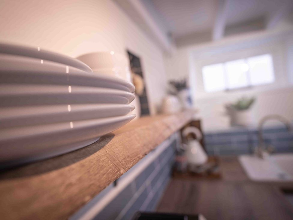A kitchen with plates on a shelf at Freya's Cottage in Metheringham