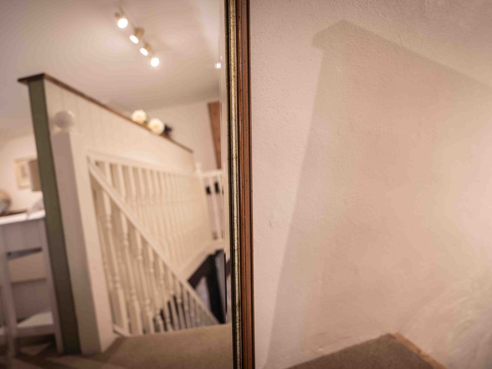 A mirror reflecting a staircase in Freya's Cottage Metheringham