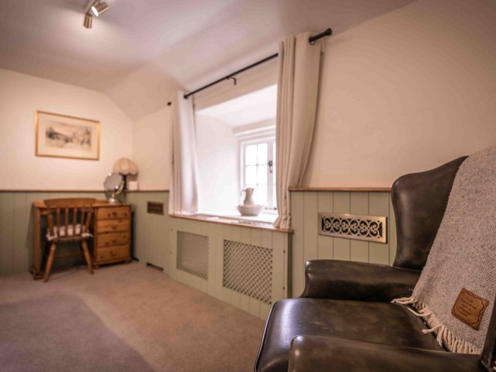 A snug with an armchair and a window at Freya's Cottage in Metheringham