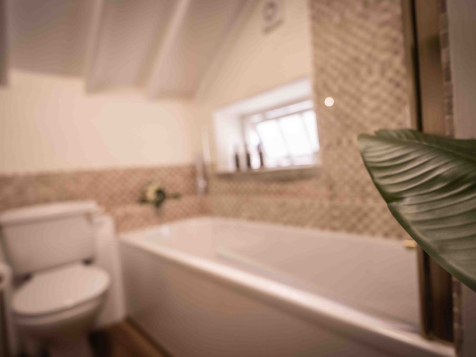 A bathroom with a bathtub and toilet at Freya's Cottage in Metheringham