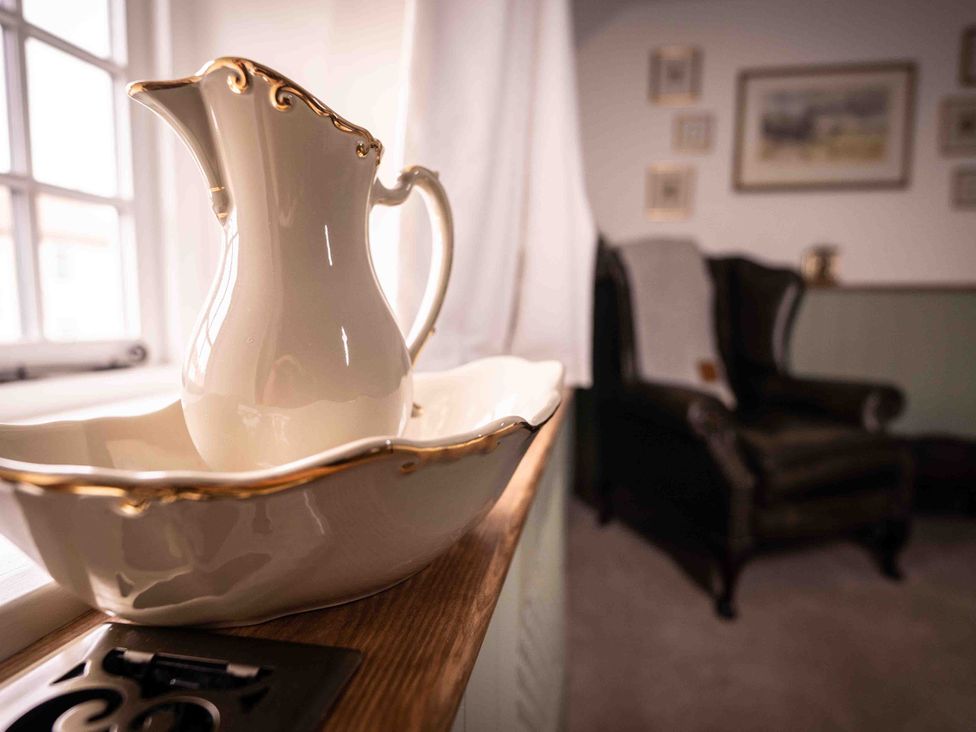 A pitcher and bowl on a table in a sitting room at Freya's Cottage in Metheringham