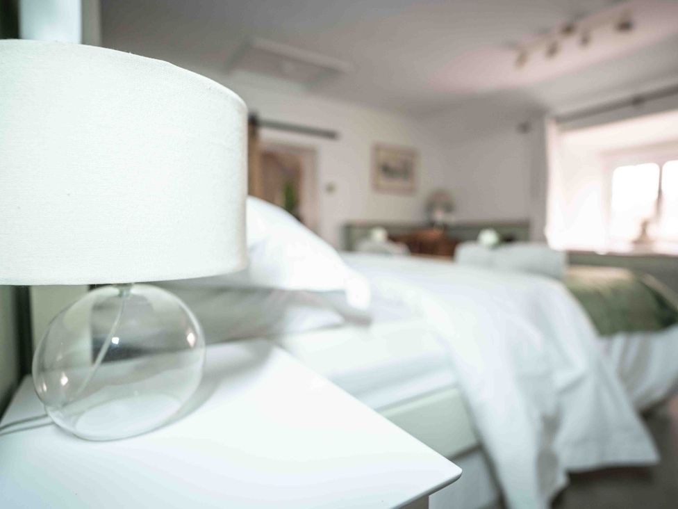 A bedroom with a lamp and bed at Freya's Cottage in Metheringham
