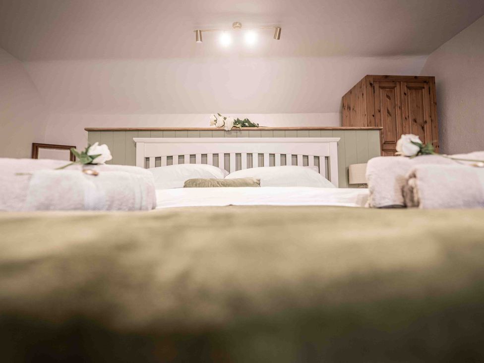 A bedroom with a bed and wardrobe at Freya's Cottage in Metheringham