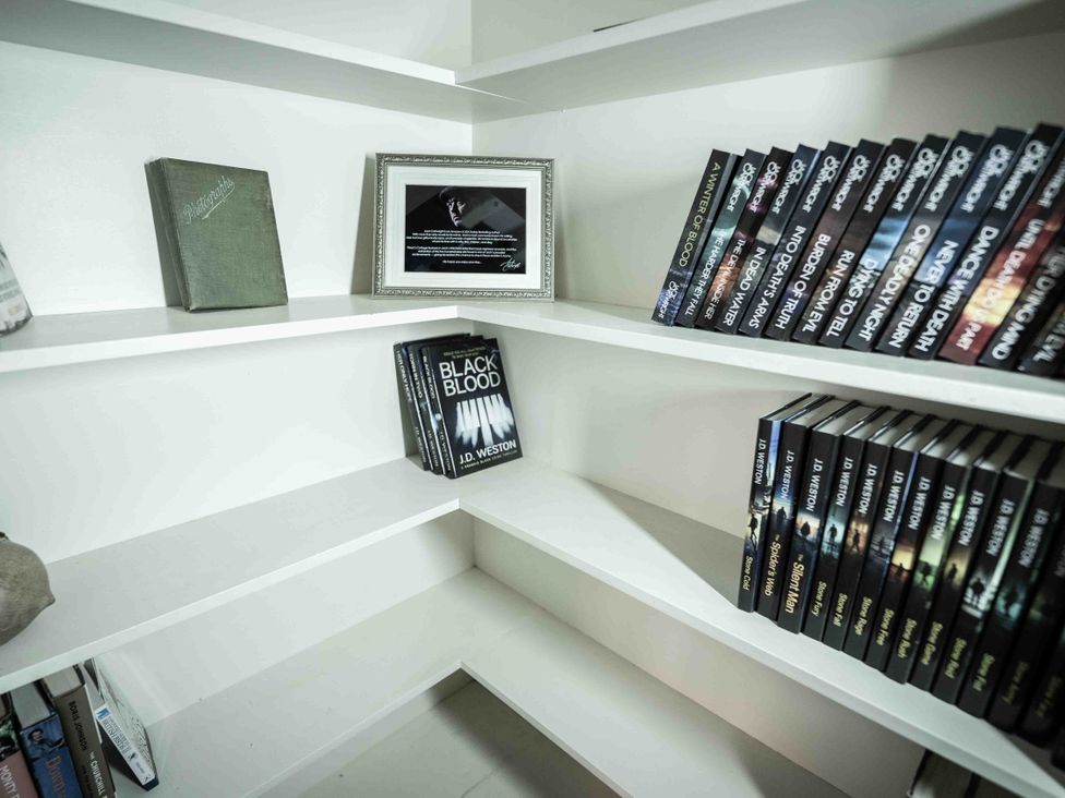 A library with books and a photo frame at Freya's Cottage Metheringham