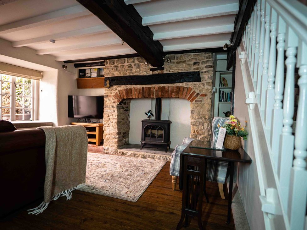 A living room with a fireplace and television at Freya's Cottage Metheringham