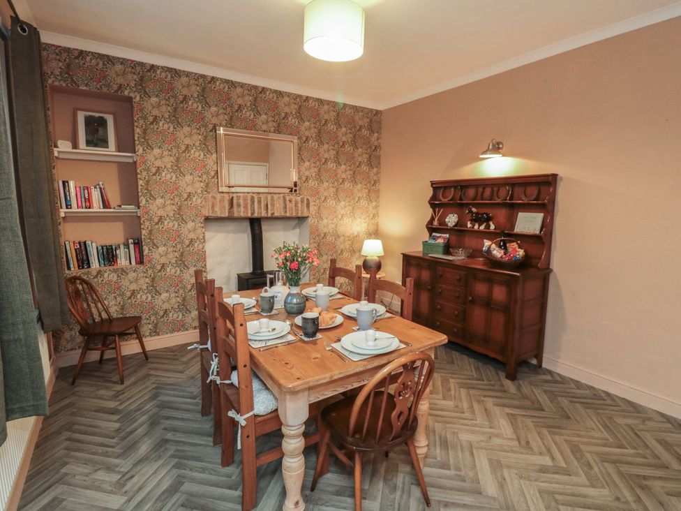 A dining room with a table set for a meal at Daisy cottage in Pickering