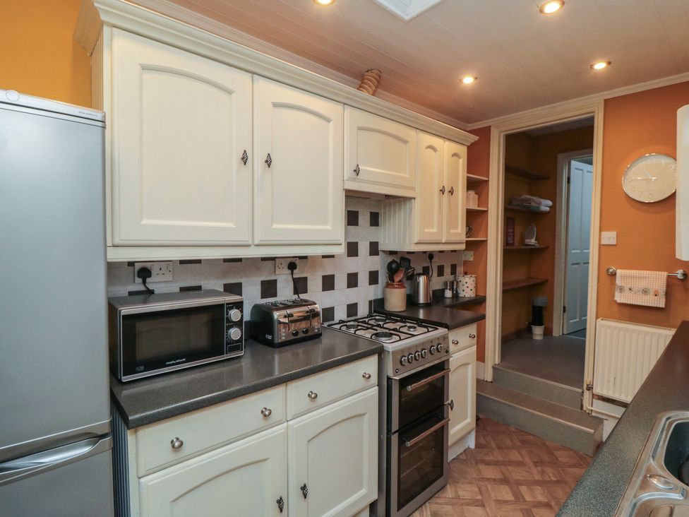 A kitchen with appliances and cabinetry at Daisy cottage in Pickering