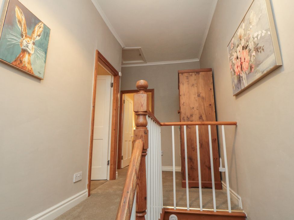 A staircase with artwork on the wall at Daisy cottage in Pickering