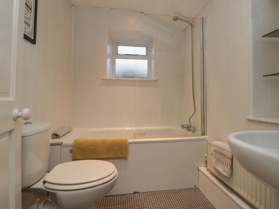 A bathroom with a bathtub and toilet at Daisy cottage in Pickering