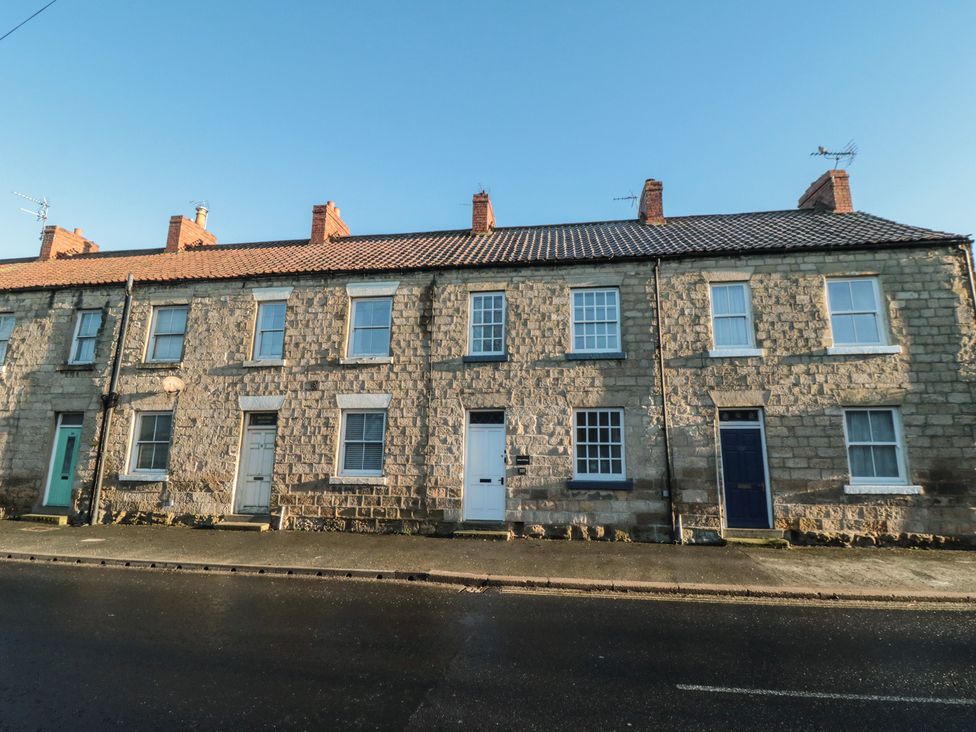 A row of stone houses with doors and windows at Daisy cottage in Pickering