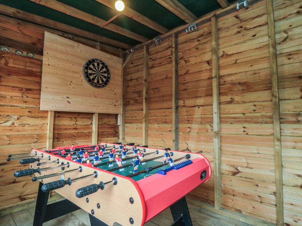 A foosball table and dartboard in a recreation room at Daisy cottage Pickering