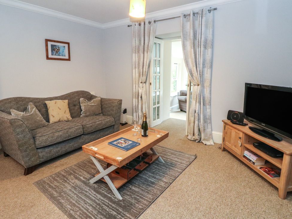A living room with a sofa and television at The Cottage in Perth