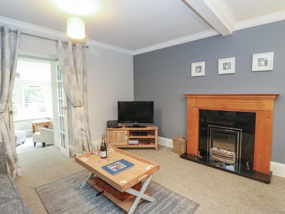 A living room with a coffee table and television at The Cottage in Perth