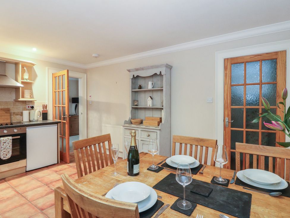 A kitchen with a dining table and cooking appliances at The Cottage in Perth