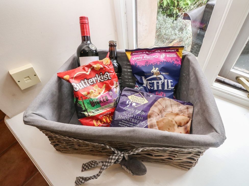 A basket with snacks and wine in a kitchen at The Cottage in Perth