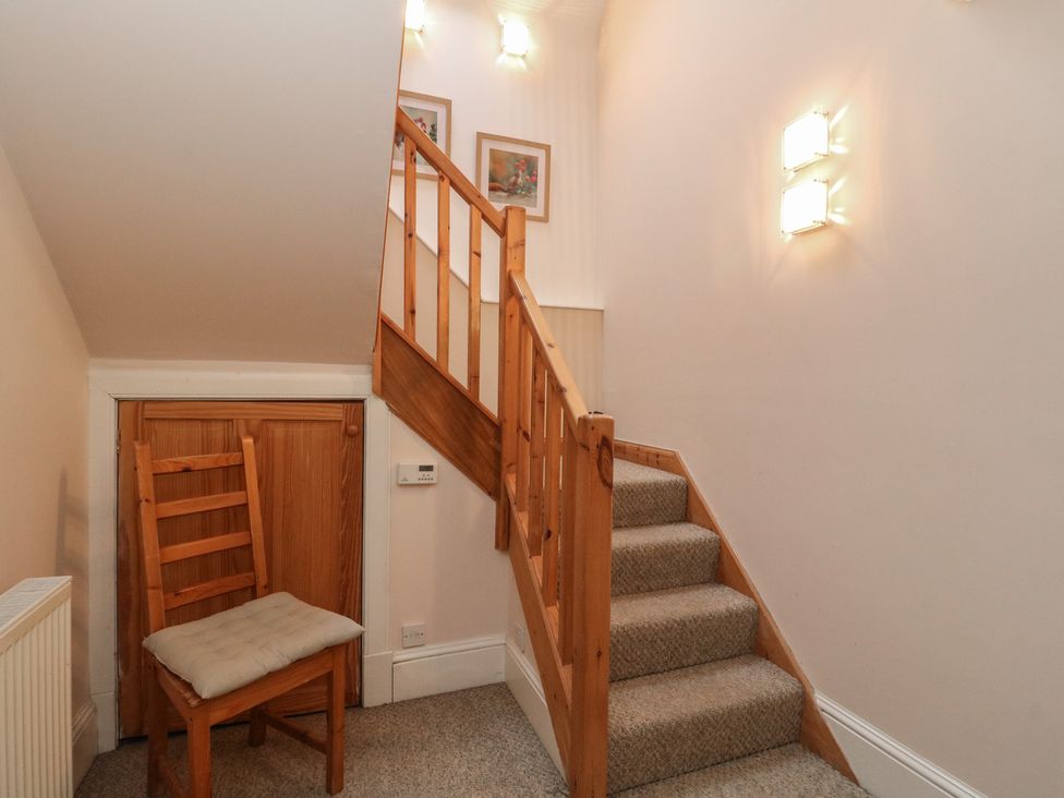 A staircase with a chair and light fixtures at The Cottage in Perth