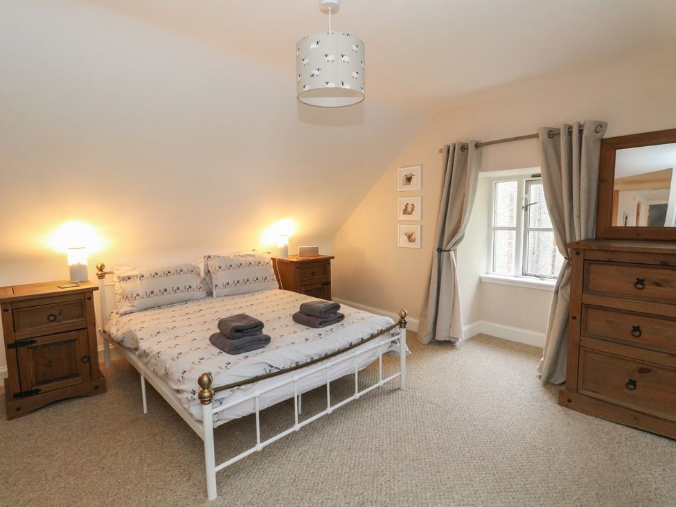 A bedroom with a bed and nightstands at The Cottage in Perth