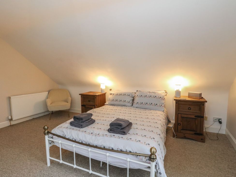 A bedroom with a bed and nightstand at The Cottage in Perth