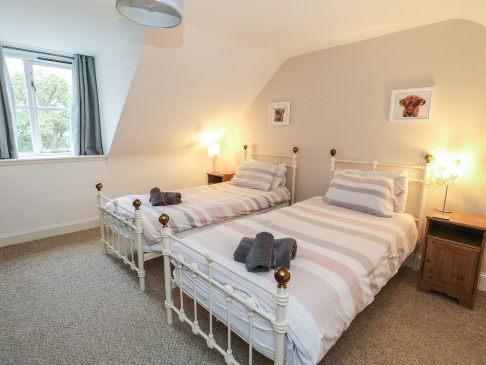 A bedroom with two beds and a bedside table at The Cottage in Perth